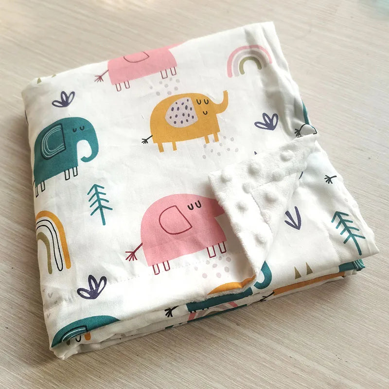 Folding of a soft baby blanket featuring colorful elephant and rainbow prints with a textured white minky dot backing.