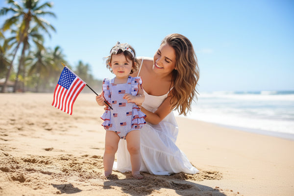 Baby wearing a patriotic dress with American flag pattern on a white background