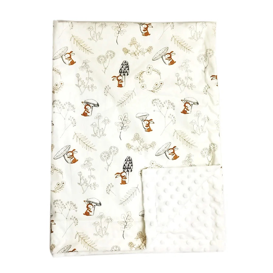Soft Minky baby blanket featuring woodland rabbits and mushrooms with a white dotted texture underside, perfect for infants.