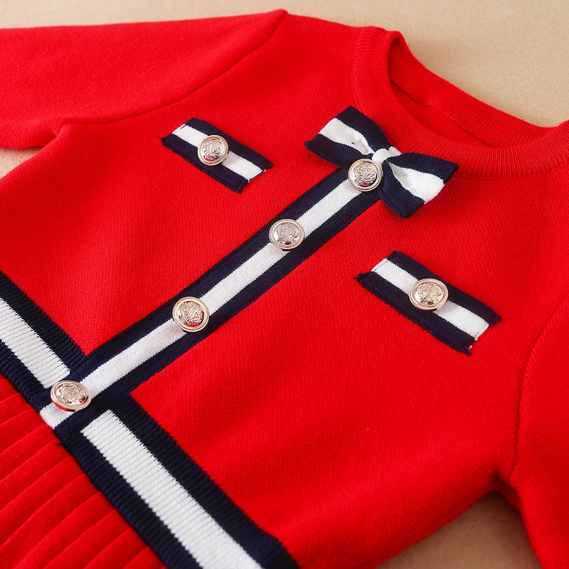 Flat lay view of the Preppy Darla Knit Dress Long Sleeves featuring elegant gold buttons and a playful bow detail. Ideal dress for stylish children aged 5 to 12.