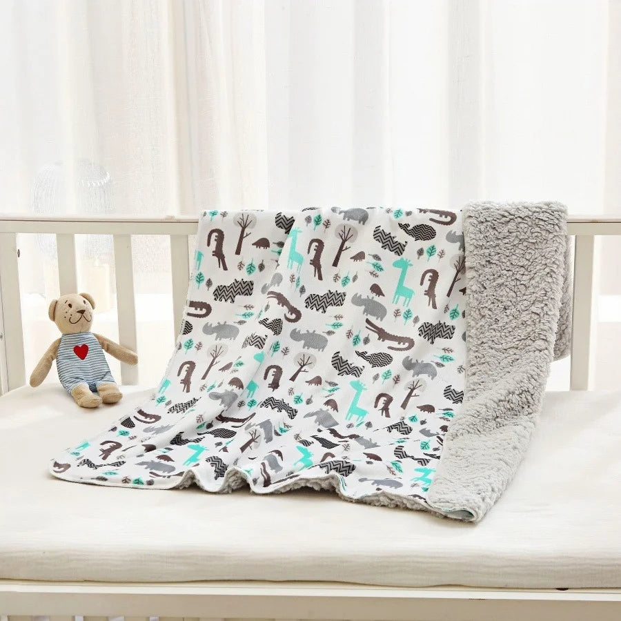 Lightweight micro-plush reversible kids blanket with teal, gray, brown animal prints on white, plush gray reverse.