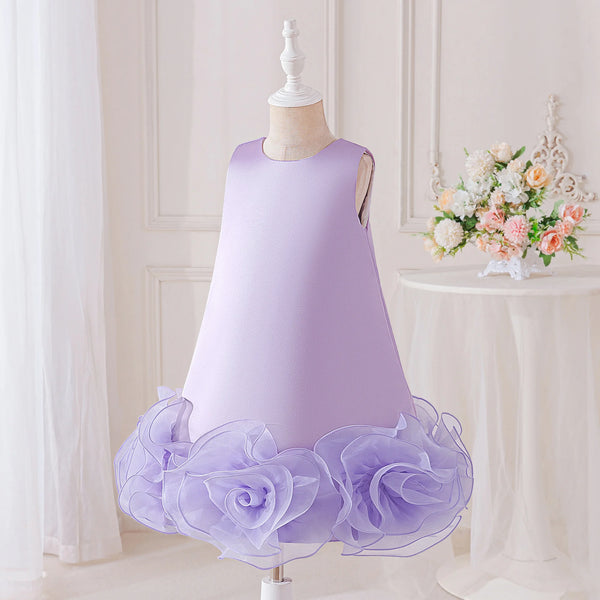 A sleeveless light purple dress displayed on a mannequin in an indoor styled setting. The dress has a fitted bodice and a layered ruffled tulle hem made of large flower-like rosettes in the same pale purple color.