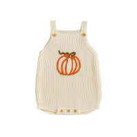 Cream knit romper overalls for babies featuring an orange pumpkin applique, wooden shoulder buttons, and bottom snap closure.