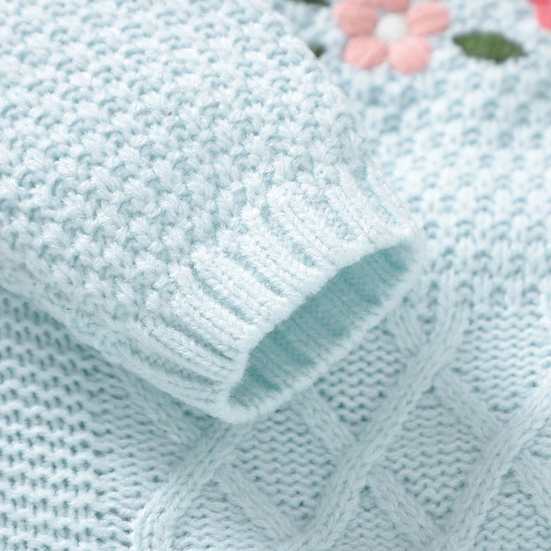 Close-up of the sleeve detail of the Precious Baby Flowers Knitted Romper With Feet, showcasing a soft blue knitted texture and colorful floral embroidery.