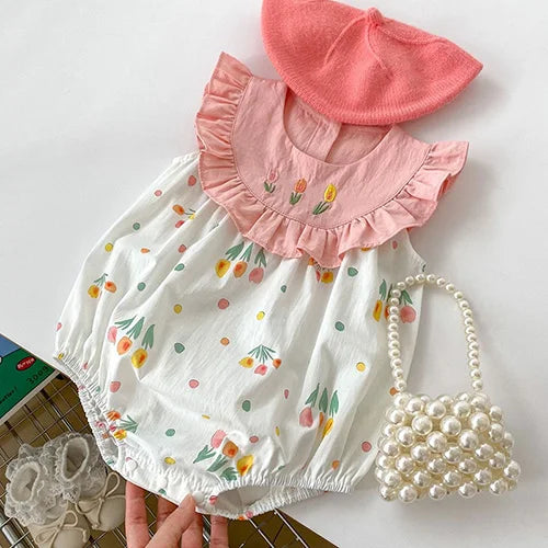 Adorable 'Summer Fleurs' Rompers for baby girls, showcasing a playful design with colorful floral patterns, complemented by a cute hat and pearl bag, ideal for sunny days.