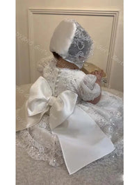 White lace baby girl baptism dress with sequins, faux pearl back buttons, large satin bow, and matching lace bonnet.