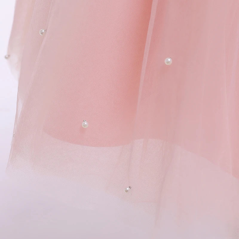 A front view of a pink 'Chantelle-Elise' V-Back Occasion Dress hanging, showcasing its stylish design and perfect for flower girls.