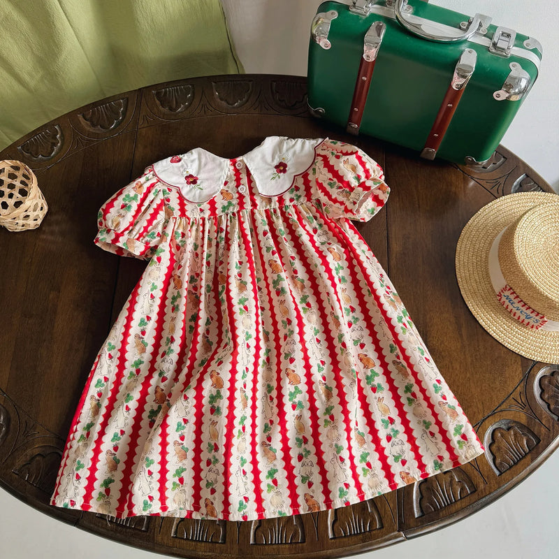 Top-down view of the 'Constance-Marie' classic embroidered dress for girls, highlighting its vibrant strawberry print and flared skirt, suitable for ages 4-6 years.