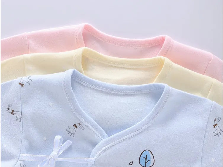Pastel pink, blue, and yellow 7-piece newborn layette set with giraffe prints and a bow detail.