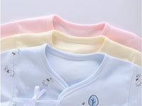 Pastel pink, blue, and yellow 7-piece newborn layette set with giraffe prints and a bow detail.