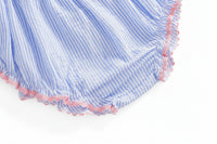 Blue-and-white seersucker fabric close-up with pink scalloped trim along the edge.