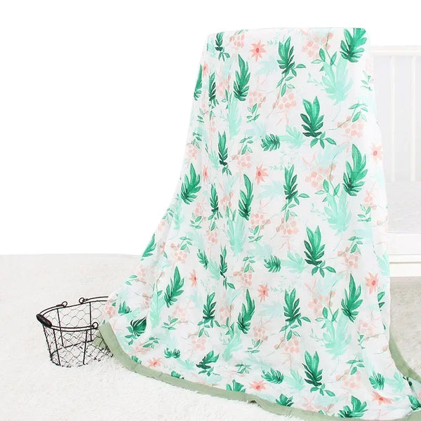 Two-layer bamboo cotton baby swaddle blanket with tropical green leaves and pink flowers on white.