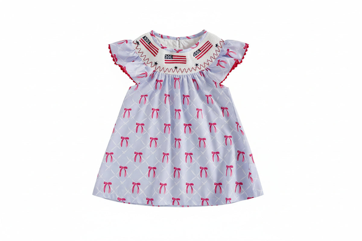 Children's dress with bow pattern and American flag design on a beige background