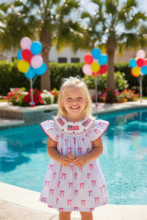 Baby dress with red bow pattern on a white background