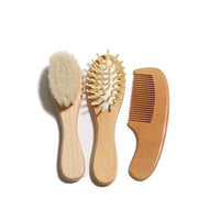 Wooden baby-to-toddler grooming set with soft-bristle brush, pin brush, and wide-tooth comb