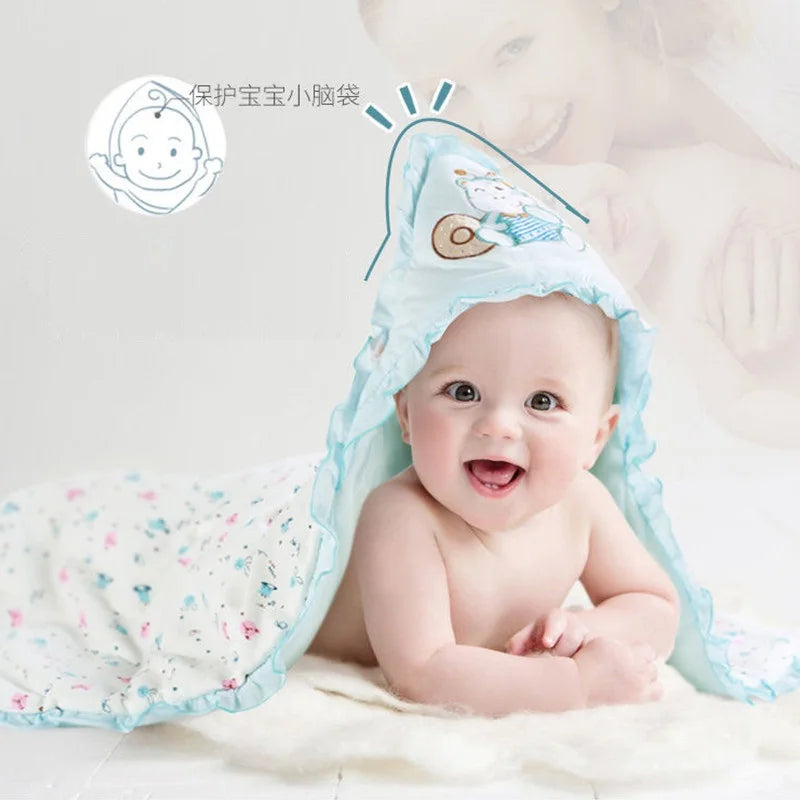 Happy baby wrapped in a light blue 'Animal Cutie' baby swaddle wrap with cute designs, ideal for keeping your little one snug.