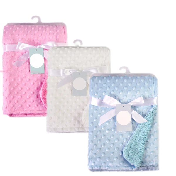Set of three dotted soft fleece baby blankets in pink, white, and blue with ribbons and tags.