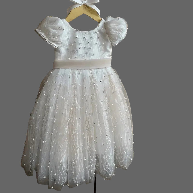 White lace dress with puff sleeves on a hanger against a neutral background