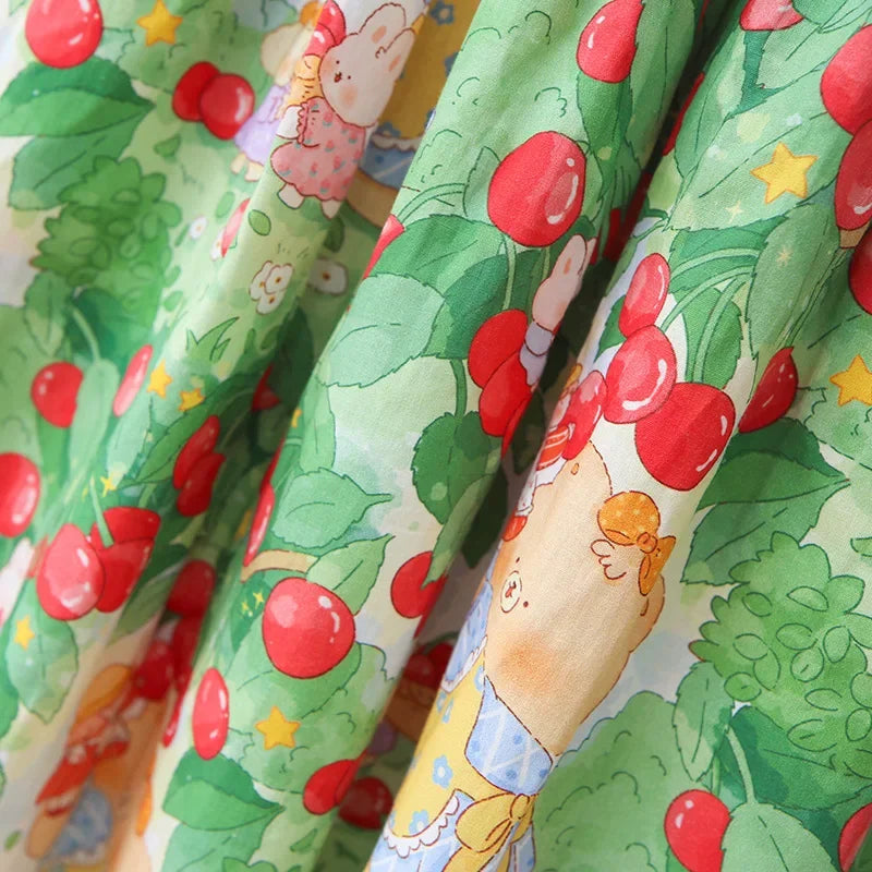 Flowing fabric of A Very Cherry Day Embroidered Dress, displaying the vibrant cherry print dress adorned with cute character designs and red cherries.