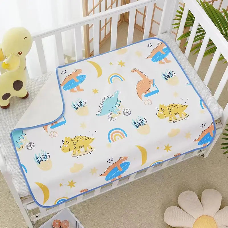 Childrens Waterproof Changing Pad in Cute Prints on a crib, cotton cover with dinosaurs and rainbow design, blue trim.