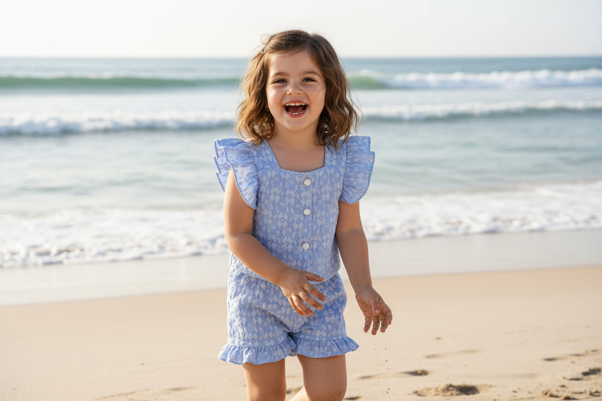 Blue frills 2-piece girls bloomer set with buttoned front, square neckline, elastic waist, and frill sleeves.