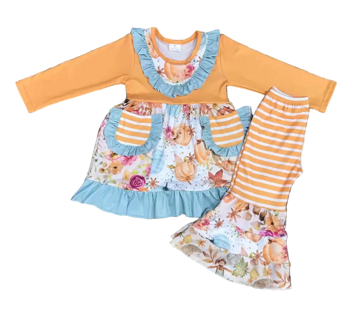 Children's outfit with floral top and striped pants on a wooden background