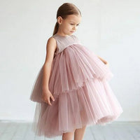 Young girl in blush pink Cara Ann tiered tulle party dress with empire waist and round neckline.