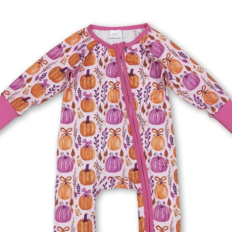 Close-up view of the 'Pumpkins and Flowers' romper zippered front, highlighting colorful pumpkin designs in hot pink.