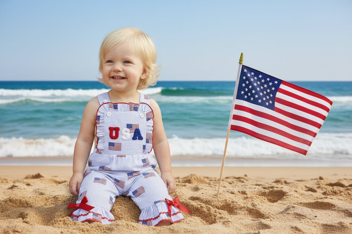 Child wearing a patriotic outfit with 'USA' on a wooden step.