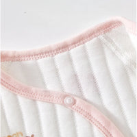 White quilted baby romper with pink trim and snap button, featuring cozy warm long sleeves for gentle comfort.