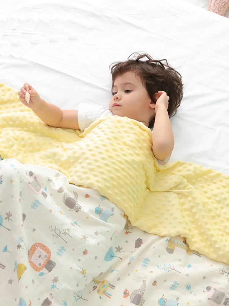Toddler wrapped in soft yellow minky blanket with cute baby animal print. Durable cotton blend, 100x75cm, perfect for sensitive skin and gifts.
