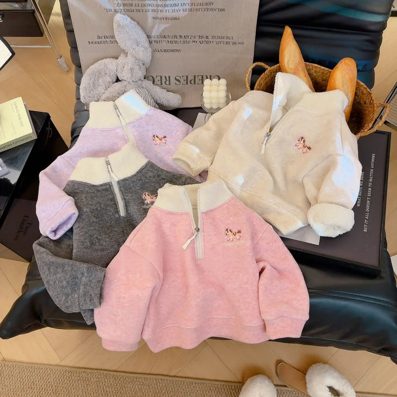 Children's cozy fleece pullover in purple, pink, white, and grey featuring an embroidered horse detail on the half-zip collar.