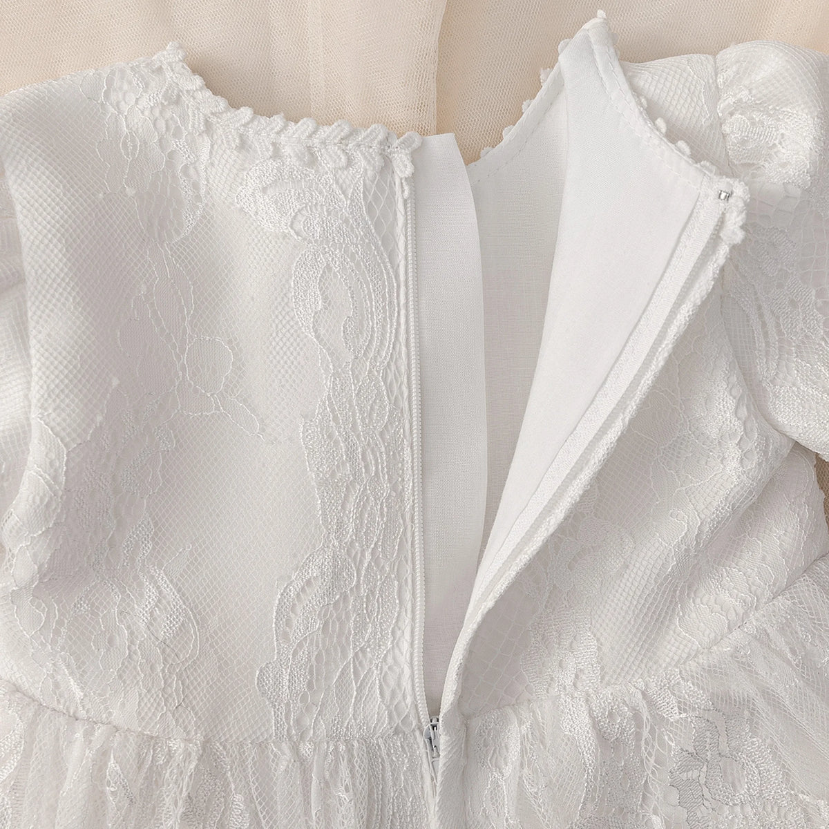 Tabitha elegant baptism flower girl dress in white lace, knee-length with zipper back, fitted bodice and flared skirt.