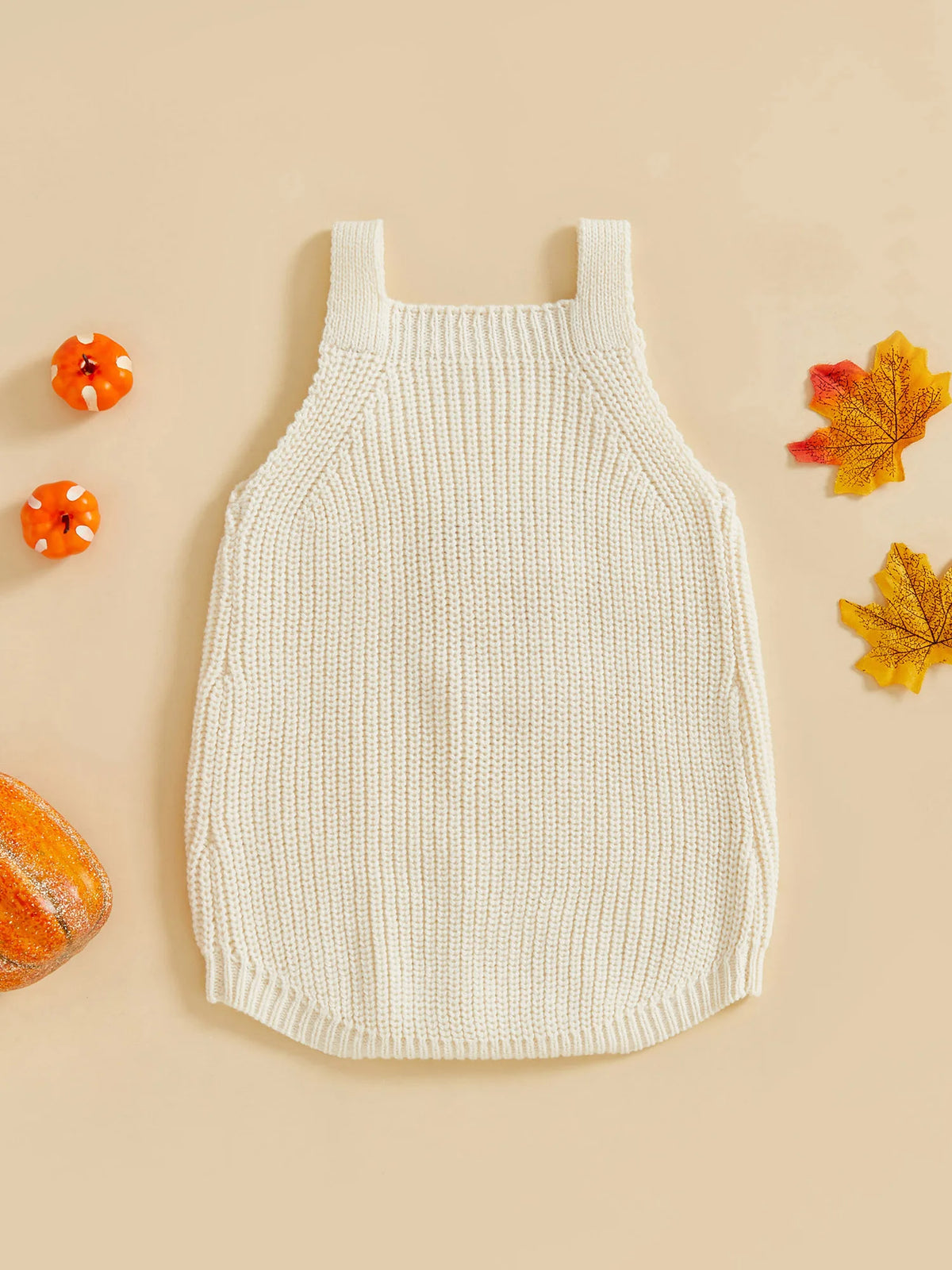 Cream ribbed knit romper overalls for babies, styled with mini pumpkins and autumn leaves for a cozy seasonal look.