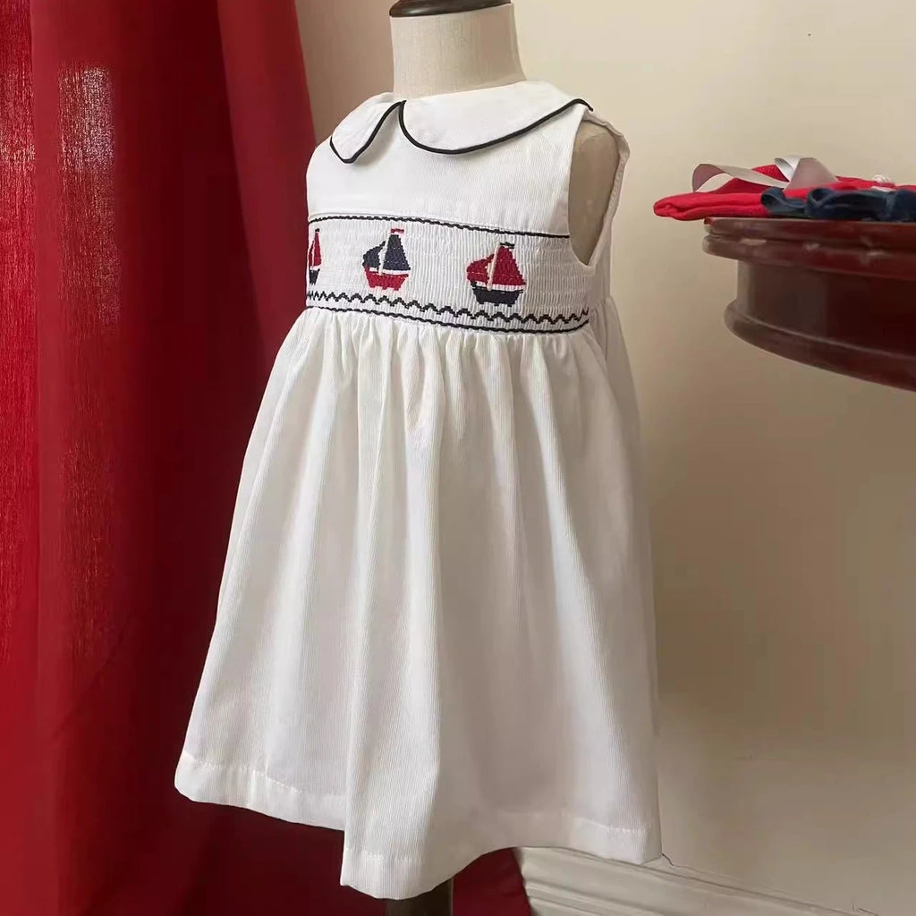 Set Sail Little Girl's Party Dress featuring hand-embroidered sailboats and a classic Peter Pan collar.