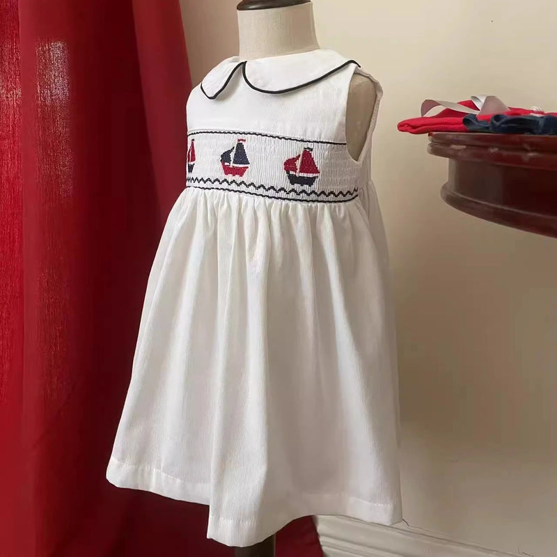 Set Sail Little Girl's Party Dress featuring hand-embroidered sailboats and a classic Peter Pan collar.