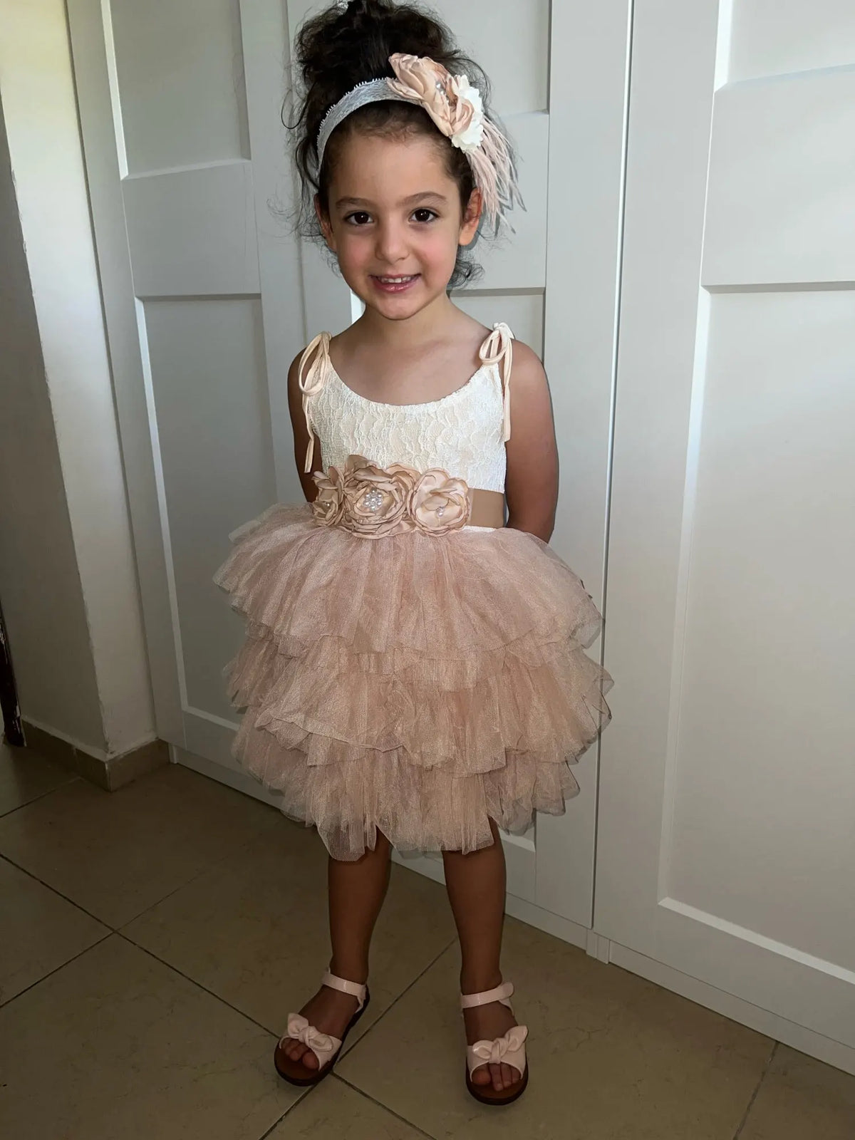 Cecilia vintage-tiered tulle dress with floral belt and matching headband worn by a young girl.