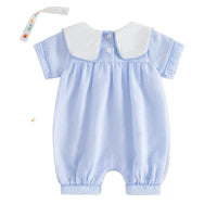 Blue checkered baby romper with white collar on a beige background
