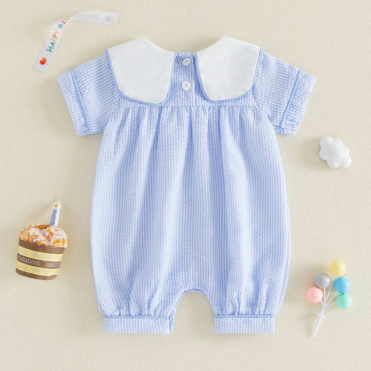 Blue checkered baby romper with white collar on a beige background