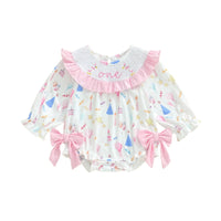 Baby romper with colorful patterns and pink accents on a white background