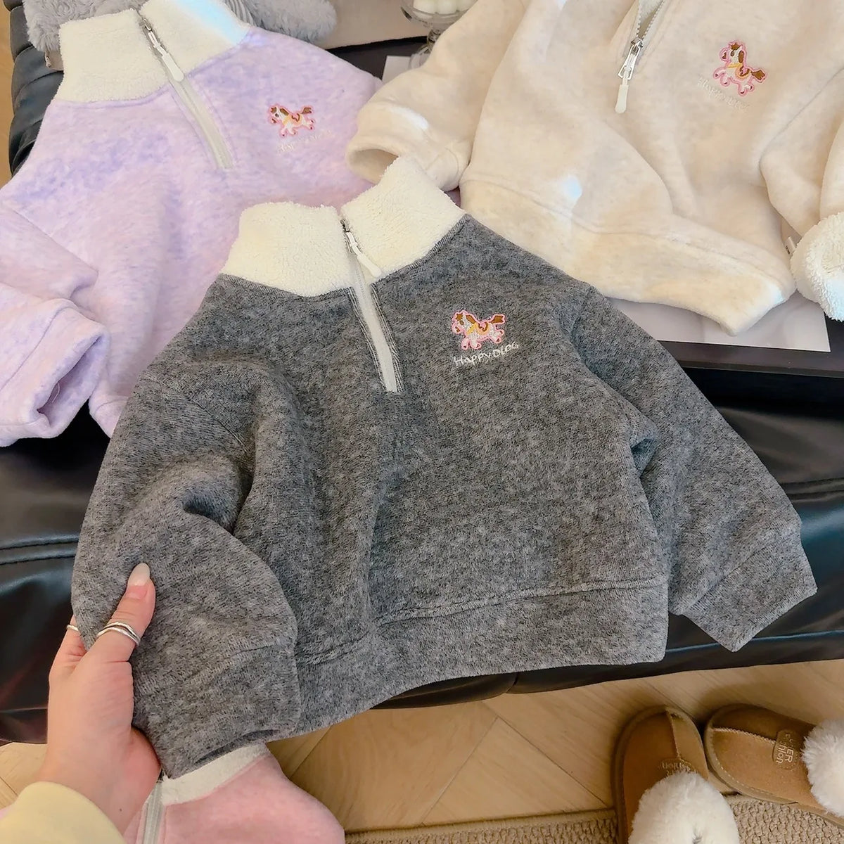 Children's gray fleece pullover with embroidered horse detail and cream collar, shown with purple and pink options for cozy fall wear.