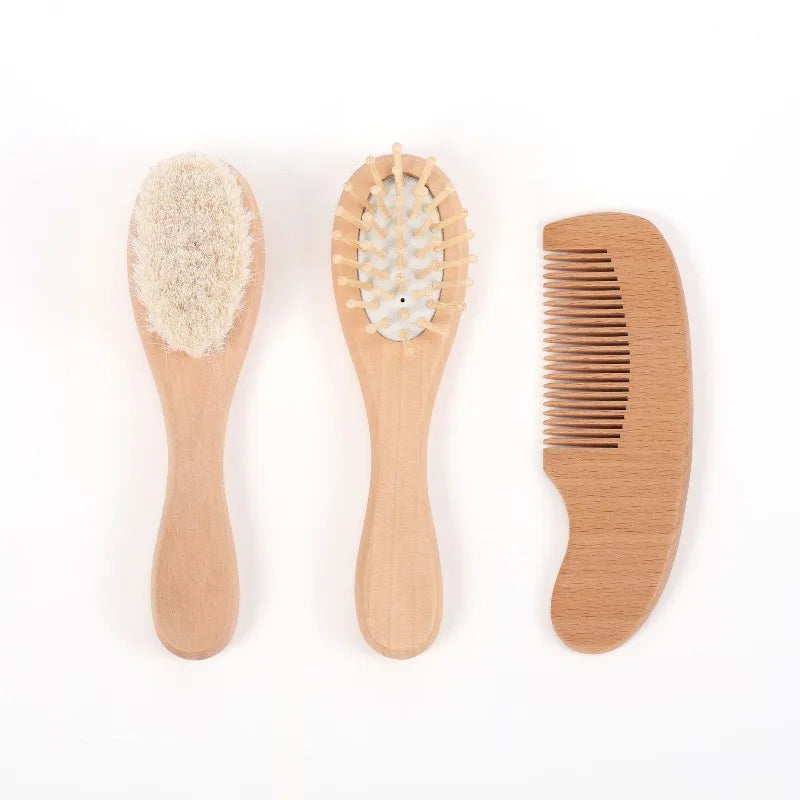 Three-piece wooden baby grooming set: soft-bristle brush, pin-style brush, and wooden comb.