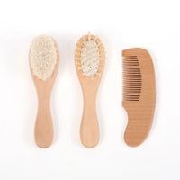 Three-piece wooden baby grooming set: soft-bristle brush, pin-style brush, and wooden comb.