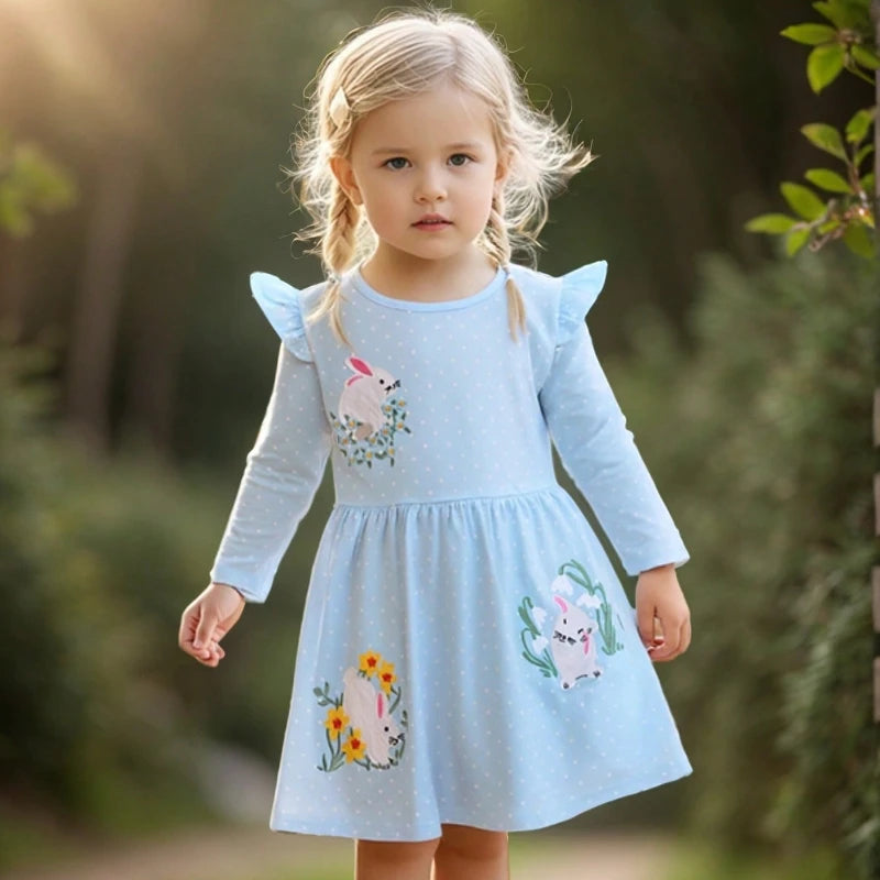 Bunny Honey Little Girls Flutter A-Line Dress modeled by a young girl in a sunny outdoor setting, showcasing embroidered bunnies and floral details.