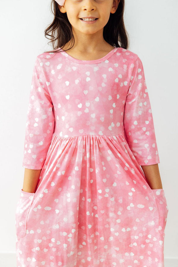Pink 3/4 sleeve pocket twirl dress with white heart print, full skirt, and ballet neckline for girls.