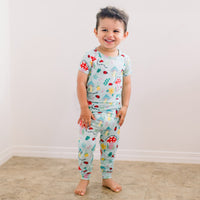 Toddler wearing The Second-Skin 2-Piece Short Sleeve Pajama in Magic Mushroom print, hand-drawn, comfortable set.