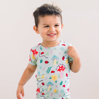 The Second-Skin 2-Piece Short Sleeve Pajama set: smiling toddler in light-blue top with colorful hand-drawn prints.