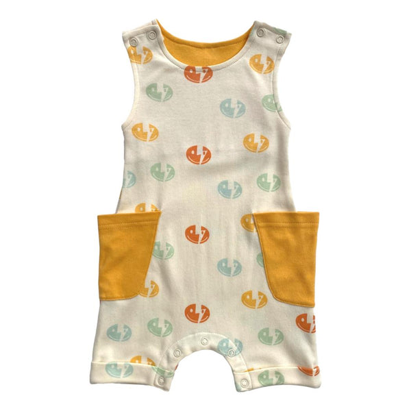 Sleeveless organic cotton romper featuring colorful smiley bolt prints and mustard yellow pockets. GOTS certified chemical-free baby fashion.