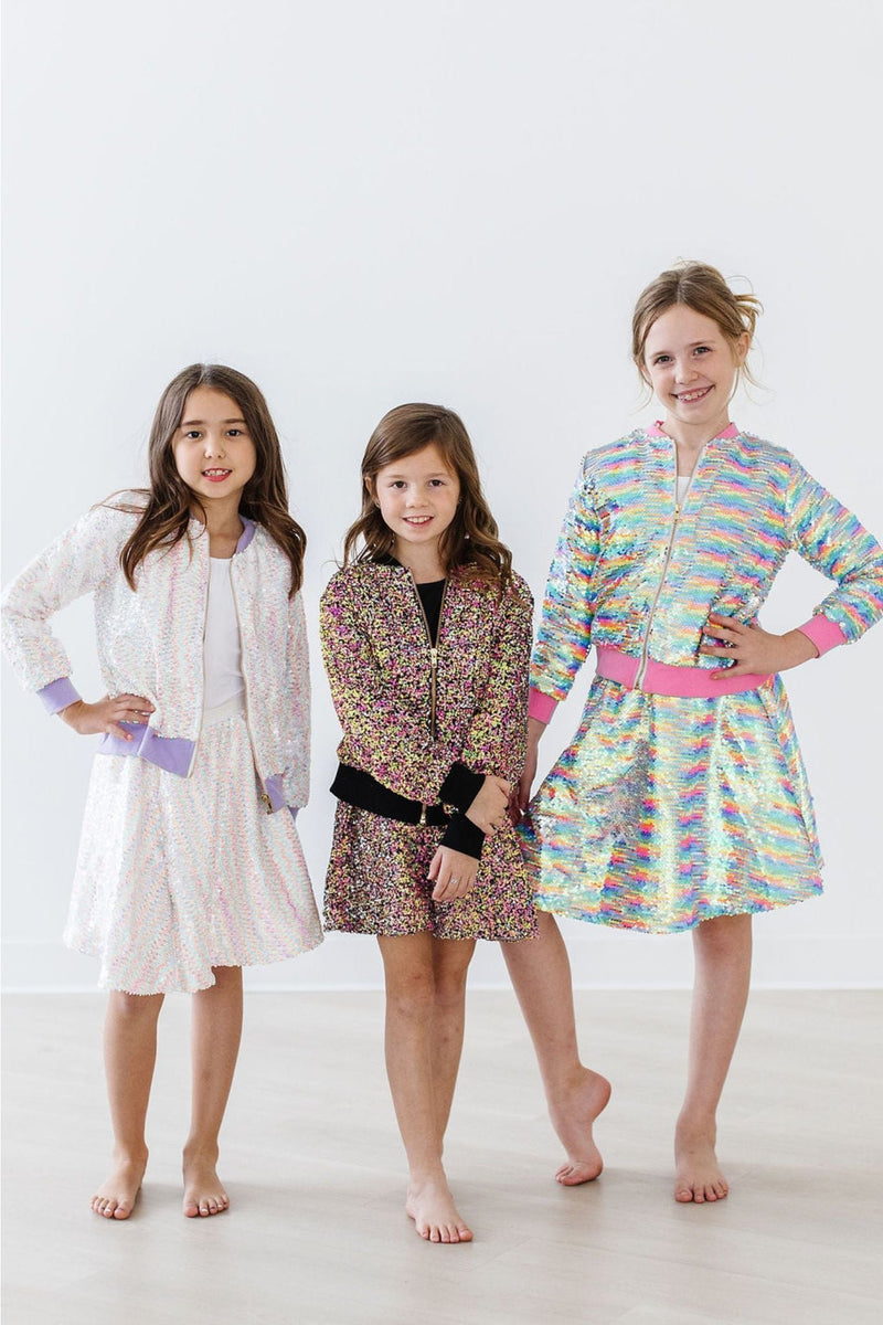 Three girls wearing colorful sequined outfits, including the Colorful Sprinkles Flip Sequin Twirl Skort for Girls, perfect for festive occasions and playful adventures.