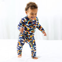 Here Comes the Sunshine blue Second-Skin Convertible Romper with rainbow sun print on a laughing toddler.